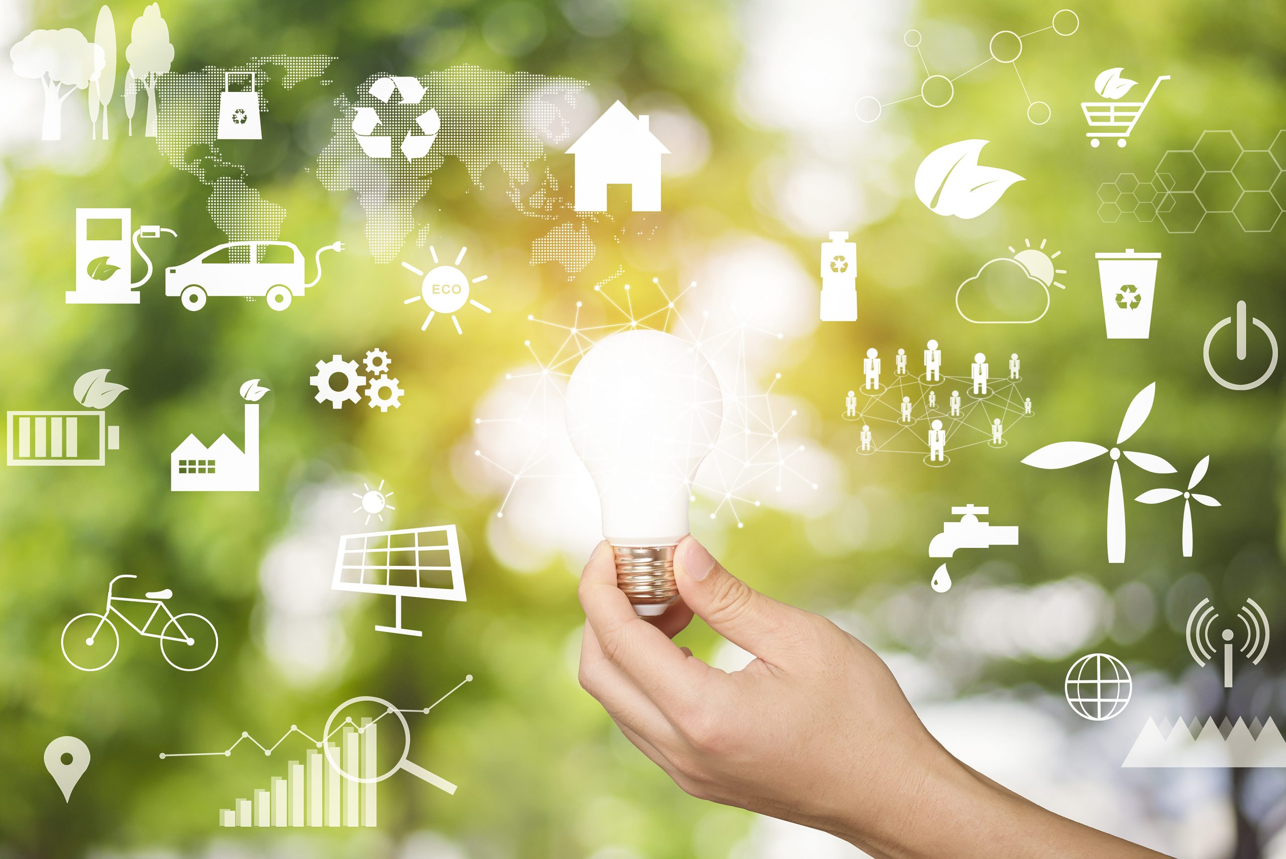 Human hand is holding light bulb on green, save earth concept.